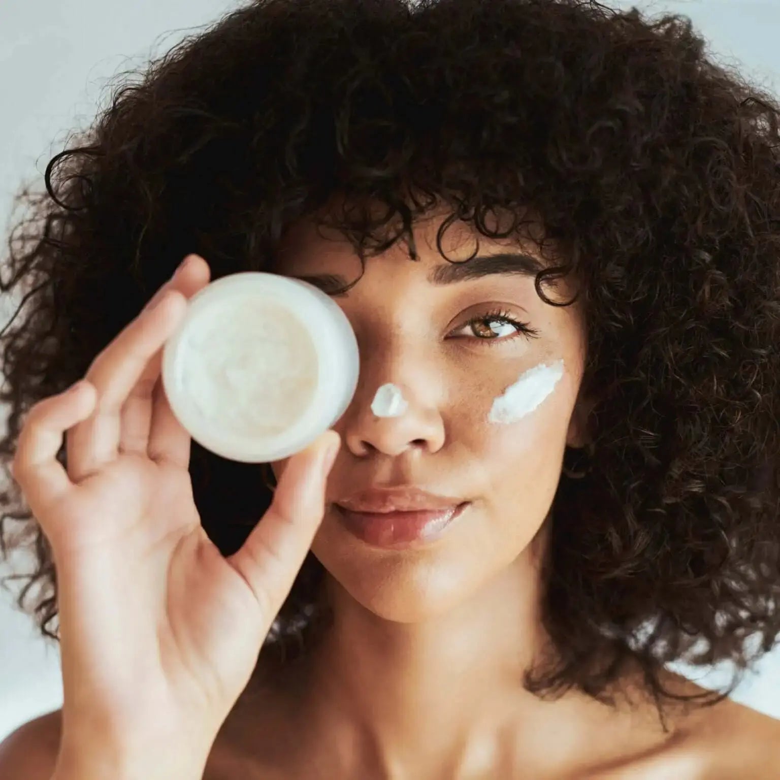 Woman applying Daily Moisture Facial Cream with Argan Oil, showcasing hydration and skin health.