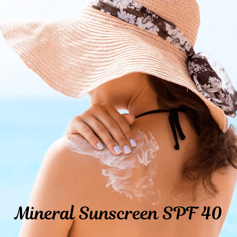 Woman applying Mineral Sunscreen Body Lotion SPF 40 with organic ingredients on sunny beach.